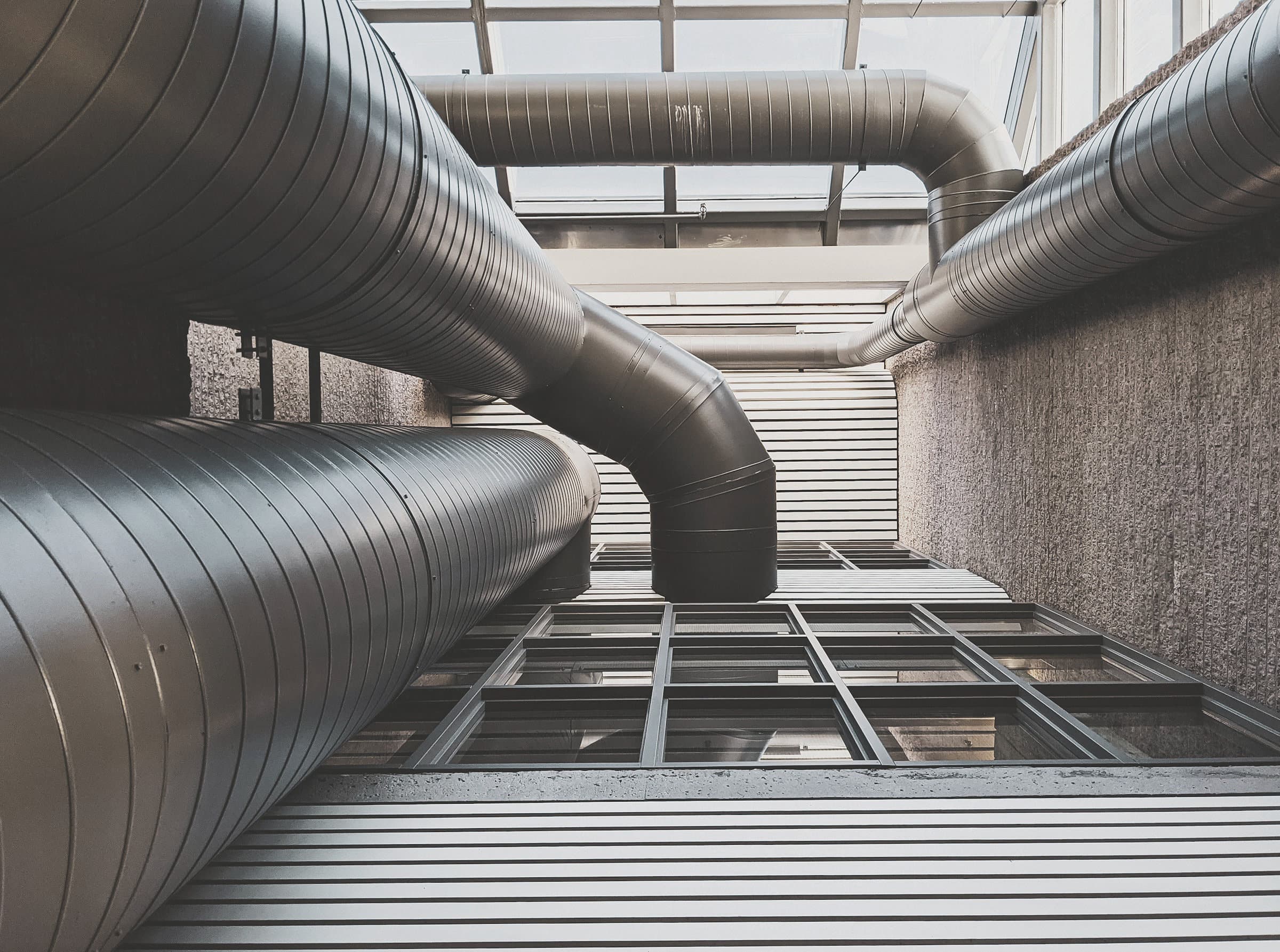 Overhead chilled water pipework packed into a shallow ceiling void
