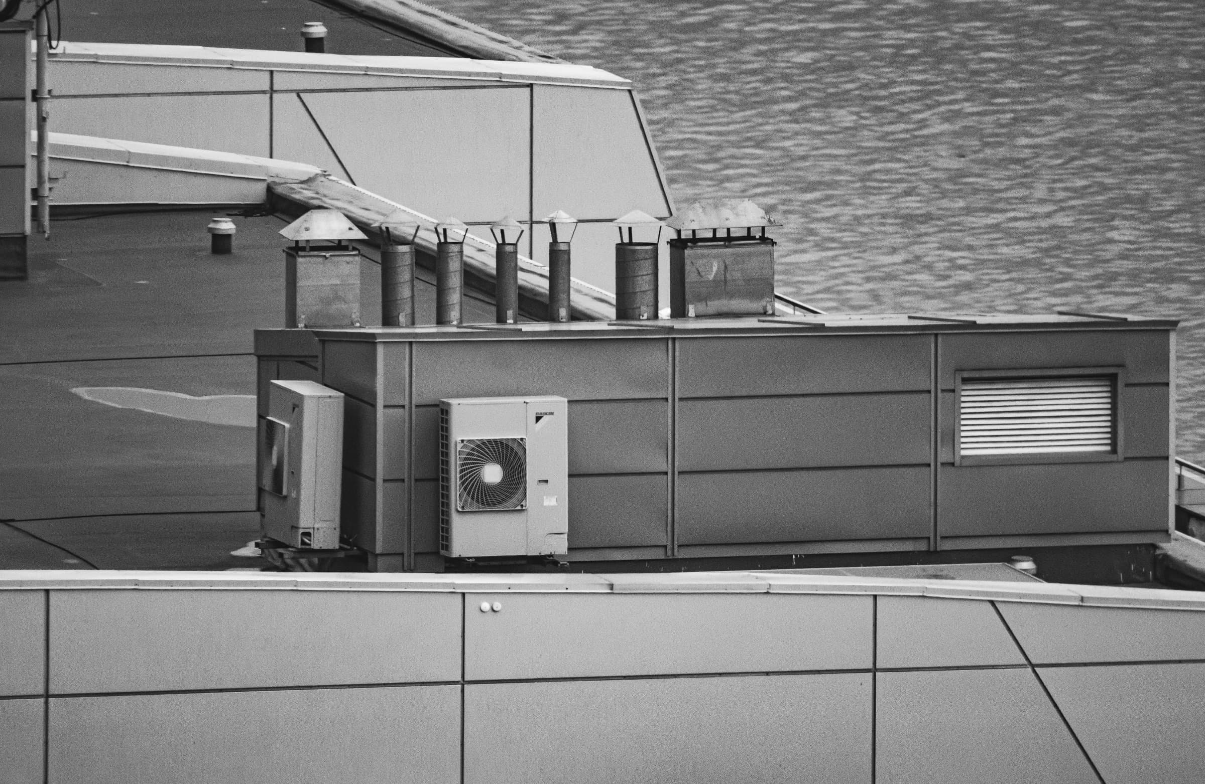 Acoustic enclosure and exhaust fan discharge on a commercial roof